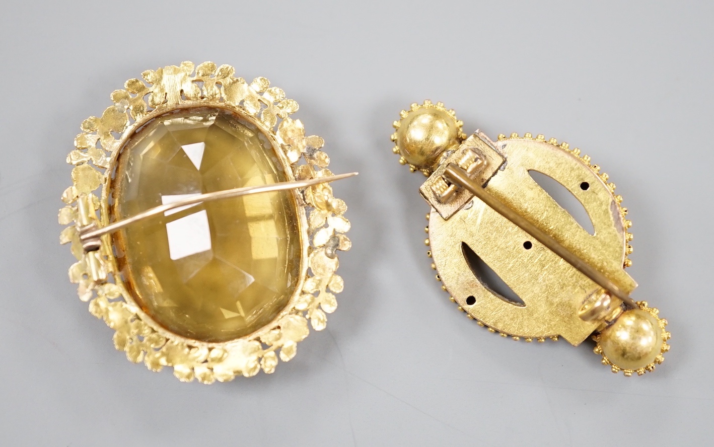 Two Victorian yellow metal brooches, one set with large oval citrine, largest 36mm, gross 19.2 grams.